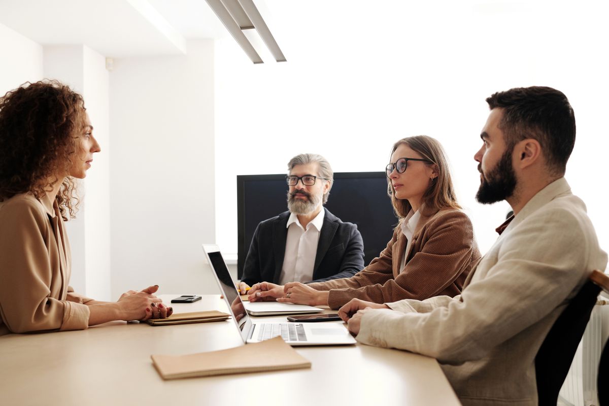Equipe em reunião corporativa analisando informações e representando a visão geral dos serviços da Ideal Contabilidade